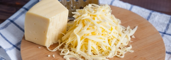 Grated block of cheese on a board