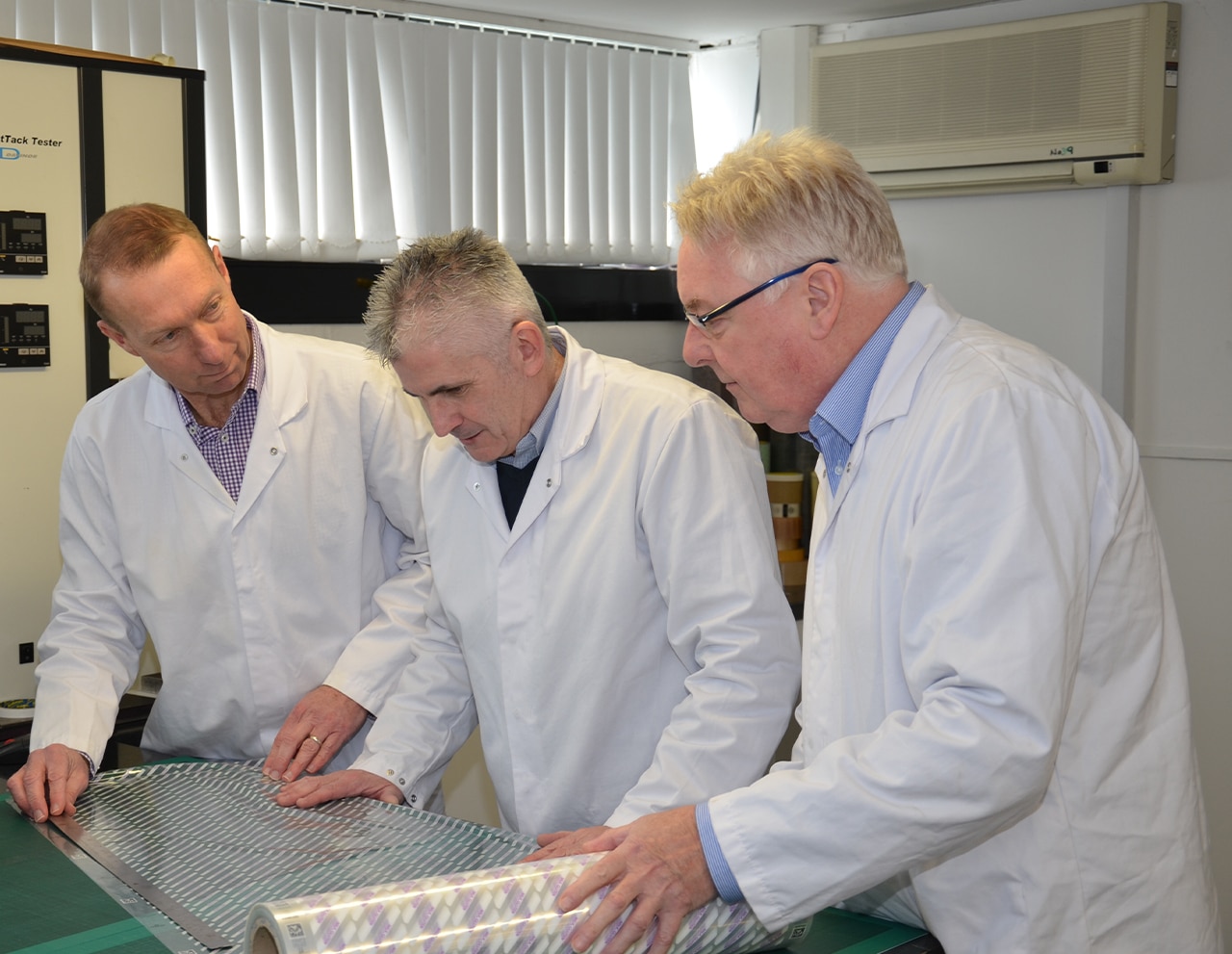 Three packaging experts looking at packaging