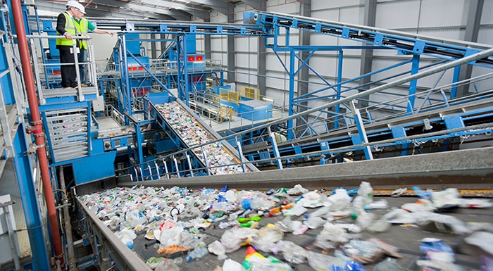 Wide,Shot,Of,Businessman,And,Worker,Talking,On,Platform,Above Wide shot of Businessman and worker talking on platform above conveyor belts in recycling plant
